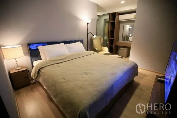 คอนโด ให้เช่าหรือขายในWatthana, Bangkok - ห้องนอนหลักบรรยากาศอบอุ่น เตียงคิงไซส์ พื้นไม้ ไฟส่องสว่าง และตู้บิลท์อิน ใกล้ BTS เอกมัย