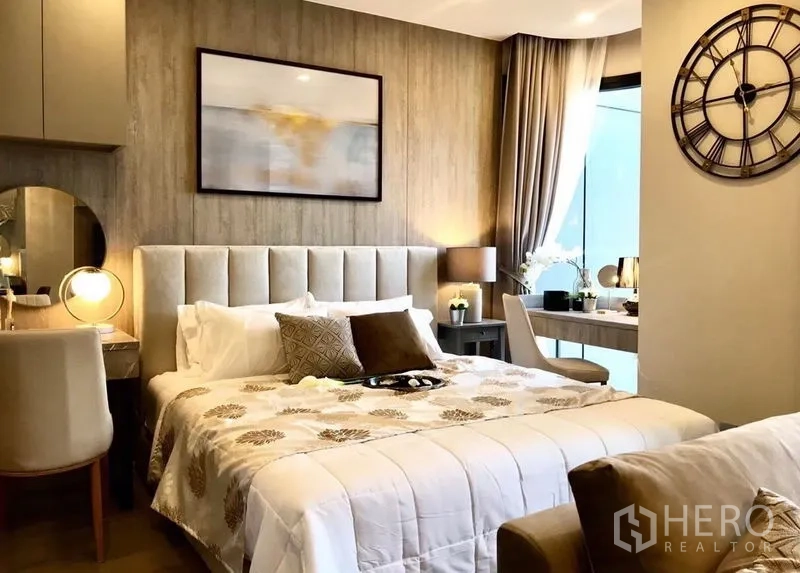 Condominium for rent in Watthana, Bangkok - Cozy bedroom with tufted headboard, bedside lamps, and desk by the window.