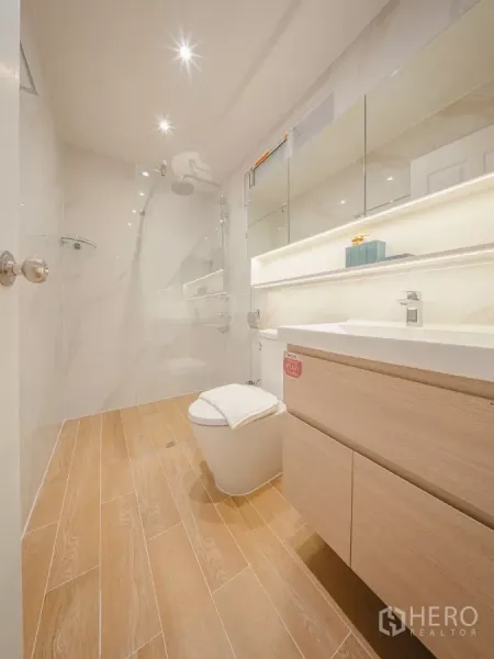 Condominium for rent in Yan Nawa, Bangkok - Contemporary bathroom with glass shower, rain head, wood-look floor and a lighted vanity.