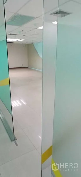 Office Space for rent in Huai Khwang, Bangkok - Bright tiled office room behind a glass partition with drop ceiling and air vents.