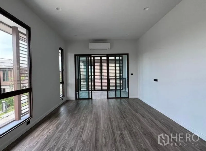 Detached House for rent in Bang Kapi, Bangkok - Primary bedroom opening to a louvered balcony through sliding glass doors.