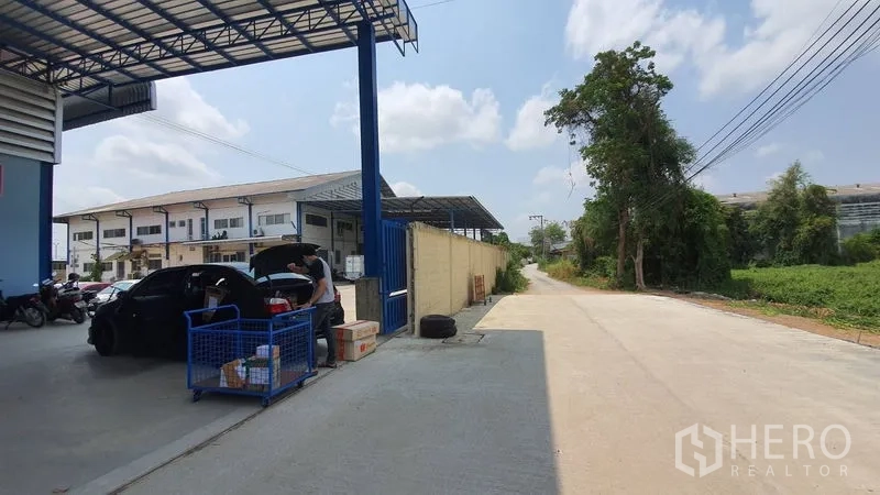 คลังสินค้า ให้เช่าในBang Kruai, Nonthaburi - ถนนทางเข้าเลียบข้างโกดัง ใต้กันสาดและมีแนวต้นไม้ริมรั้ว