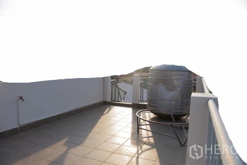联排别墅 出租在Watthana, Bangkok - 屋顶露台，瓷砖地面、栏杆与不锈钢水箱。