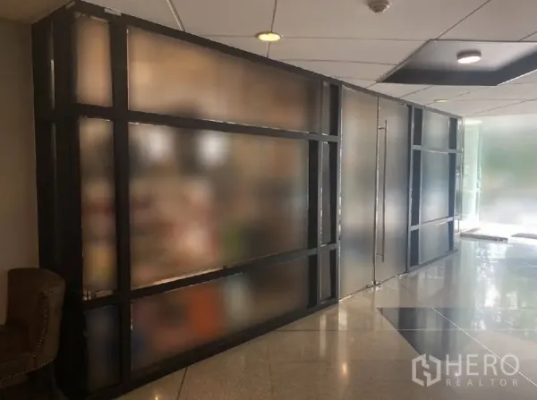 零售空间 出租在Watthana, Bangkok - 一层零售铺面，磨砂玻璃门面、光亮大堂地面与嵌入式顶灯。