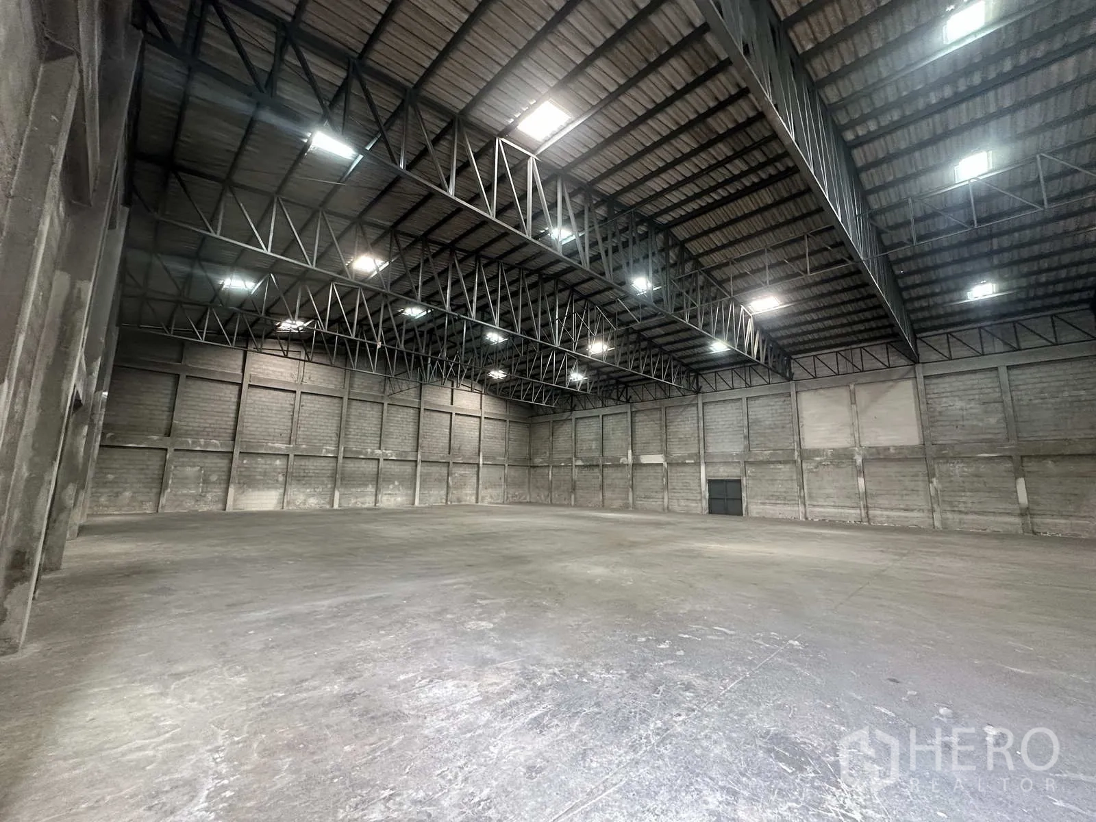 คลังสินค้า ให้เช่าในPhra Nakhon Si Ayutthaya - พื้นคอนกรีตเรียบกับโครงทรัสเหล็กและไฟบนเพดาน