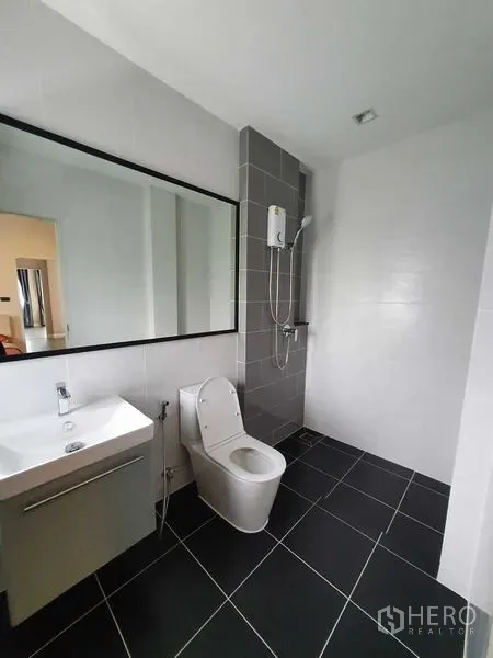 独立式住宅 出租在Khlong Luang, Pathum Thani - 现代化浴室，超长镜面、墙挂花洒与黑色地砖。