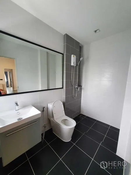 独立式住宅 出租在Khlong Luang, Pathum Thani - 现代化浴室，超长镜面、墙挂花洒与黑色地砖。