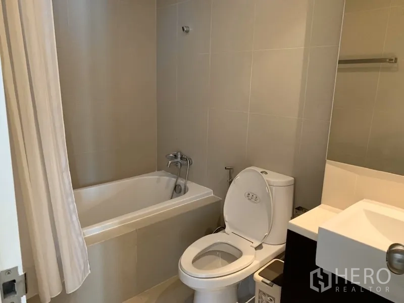 คอนโด ให้เช่าในKhlong Toei, Bangkok - ห้องน้ำโทนอบอุ่น มีอ่างอาบน้ำ โถสุขภัณฑ์ อ่างล้างหน้า และผนังกระเบื้อง