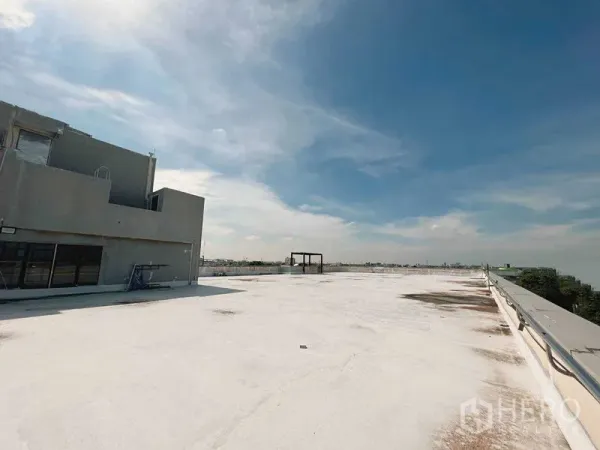 零售空间 出租在Yan Nawa, Bangkok - 曼谷Yan Nawa宽阔的白色屋顶平台，带核心机房与安全栏杆，蓝天下景致开阔。