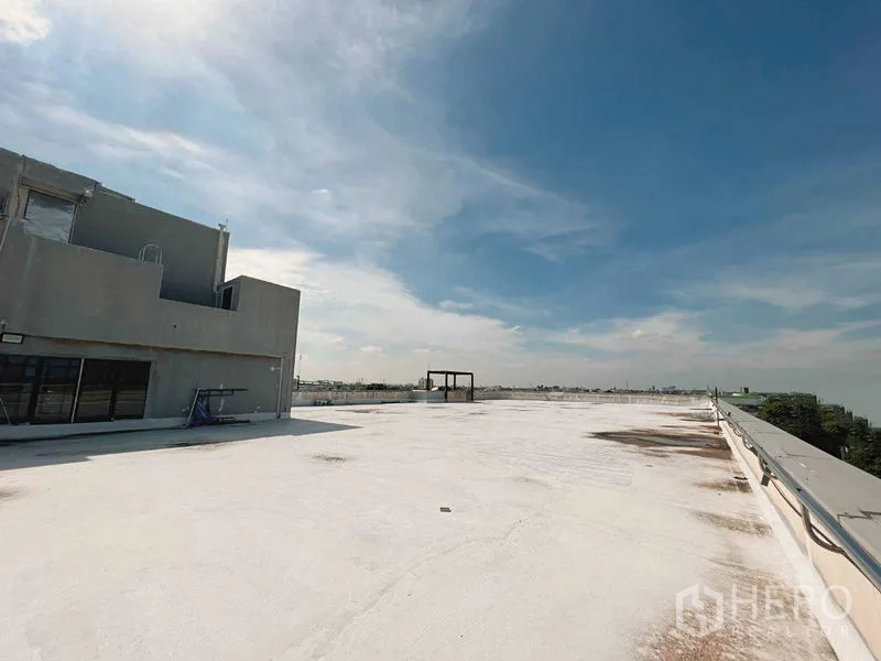 零售空间 出租在Yan Nawa, Bangkok - 曼谷Yan Nawa宽阔的白色屋顶平台，带核心机房与安全栏杆，蓝天下景致开阔。