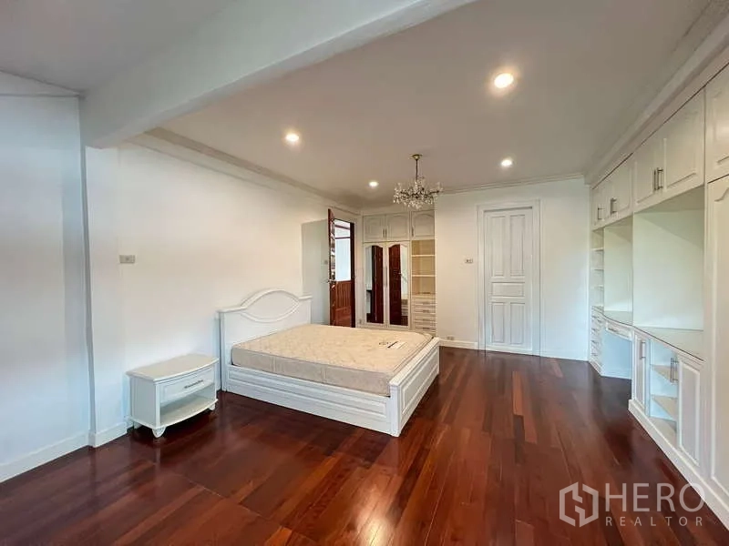 Detached House for rent in Chatuchak, Bangkok - Expansive bedroom with recessed lights and full-length storage cabinetry.