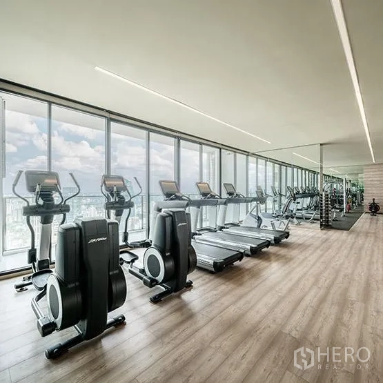 คอนโด ให้เช่าหรือขายในKhlong Toei, Bangkok - ห้องฟิตเนสคอนโดพร้อมลู่วิ่งและจักรยาน มองเห็นวิวเมืองผ่านผนังกระจกเต็มบาน