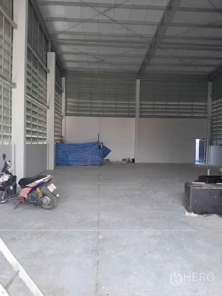货栈 出租或出售在Krathum Baen, Samut Sakhon - 仓库内部挑高空间，混凝土地面与通风玻璃砖墙面。