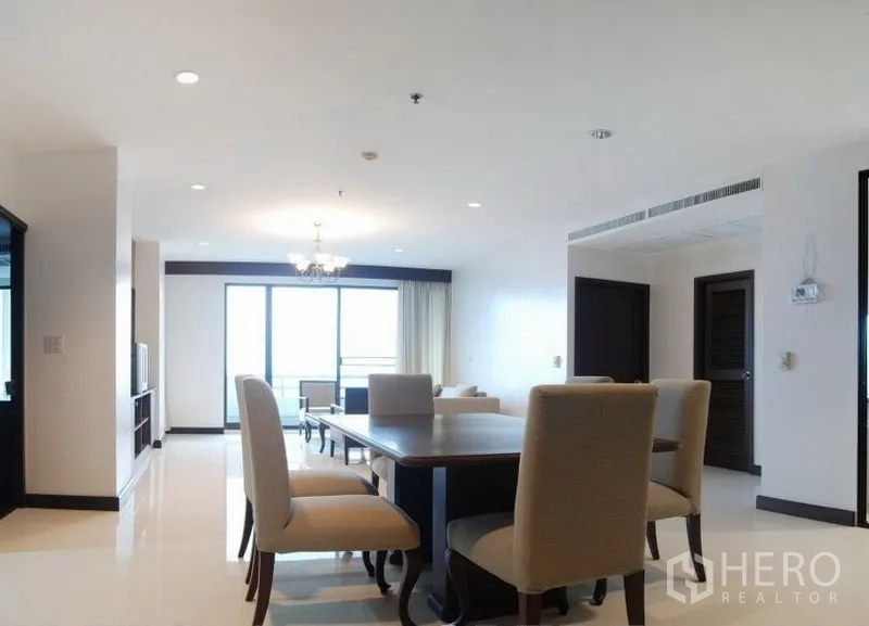 Condominium for rent in Watthana, Bangkok - Bright open-plan living and dining room with chandelier and balcony doors.