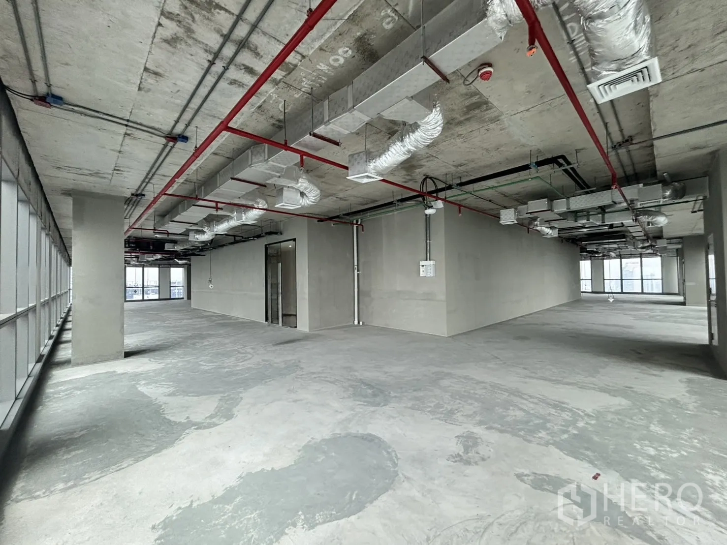 Office Space for rent in Huai Khwang, Bangkok - Open office shell with exposed ceiling, concrete floor and city-facing windows.