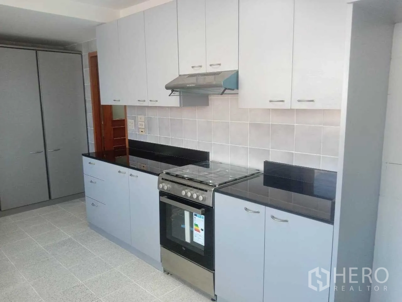 คอนโด ให้เช่าในKhlong Toei, Bangkok - ครัวสไตล์โมเดิร์น ตู้สีขาว เคาน์เตอร์หินแกรนิตสีดำ และเตาอบแก๊ส