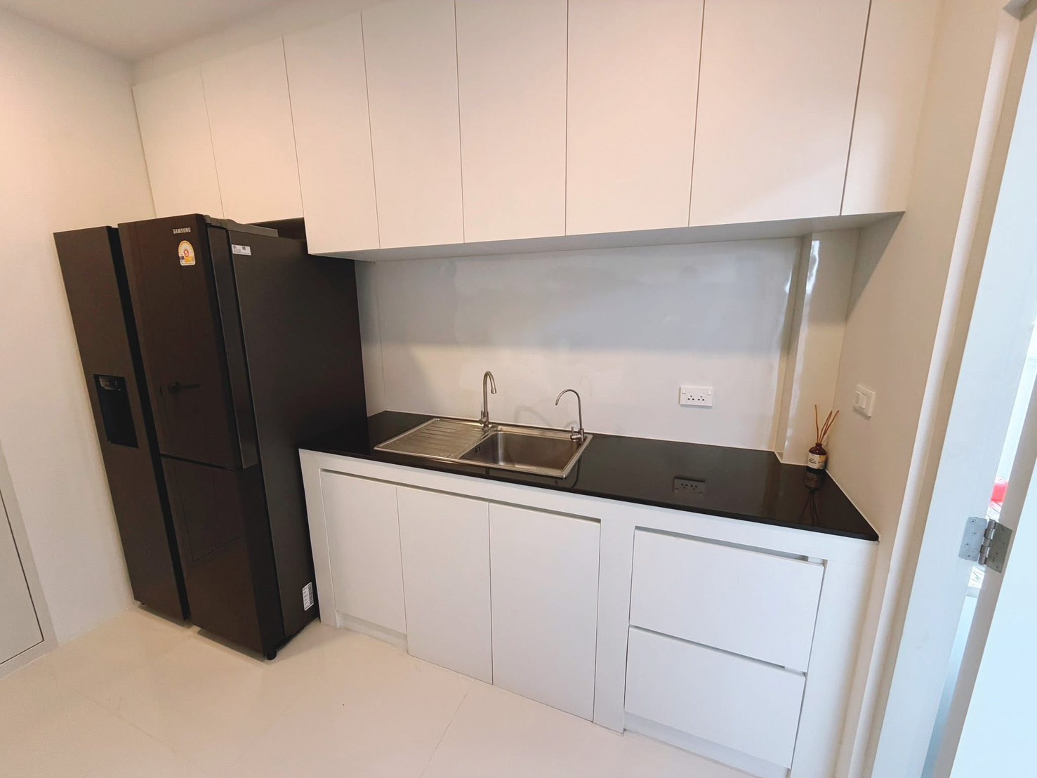 独立式住宅 出租在Bang Phli, Samut Prakan - 第二排台面配水槽，白色橱柜和大冰箱。