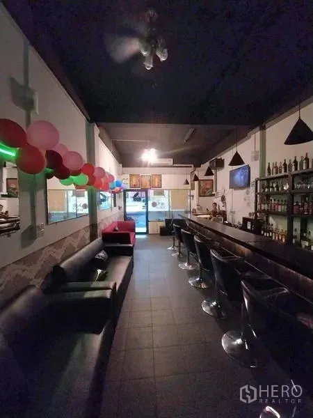 店屋 出租在Khlong Toei, Bangkok - 吧廊区，沙发、酒架和气球装饰，临近店面入口。