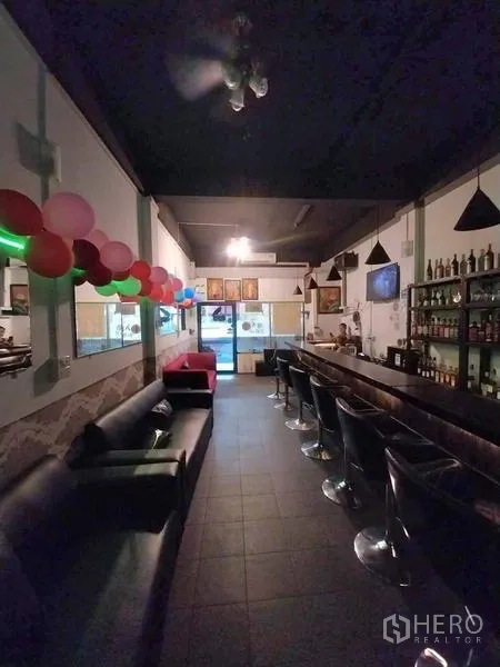 店屋 出租在Khlong Toei, Bangkok - 吧廊区，沙发、酒架和气球装饰，临近店面入口。