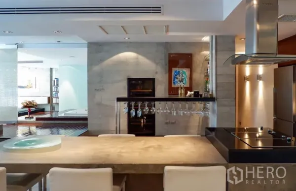 คอนโด ให้เช่าหรือขายในKhlong Toei, Bangkok - ครัวโมเดิร์นมีไอส์แลนด์เตาไฟฟ้า เครื่องใช้สแตนเลส และที่แขวนแก้วไวน์ มองไปยังโซนสปา.