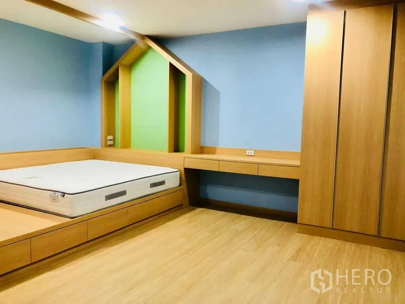 Home Office for rent or sale in Pak Kret, Nonthaburi - Bedroom with built-in wood wardrobes, platform bed and a house-shaped wall niche.