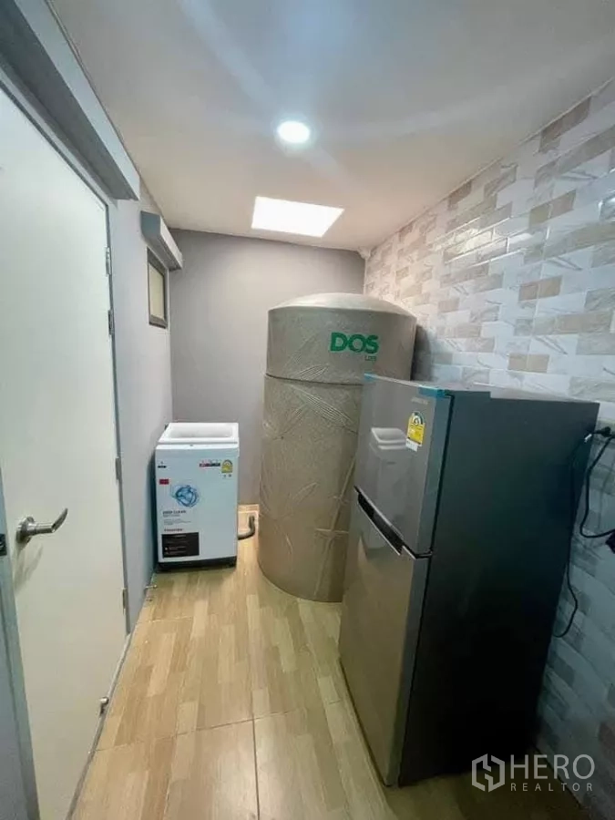 Townhouse for rent in Bang Phli, Samut Prakan - Utility area with refrigerator, washing machine and water tank.