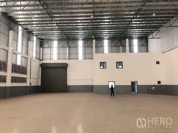 Factory for rent or sale in Bang Phli, Samut Prakan - Open factory floor showing loading roller door and attached internal office block.