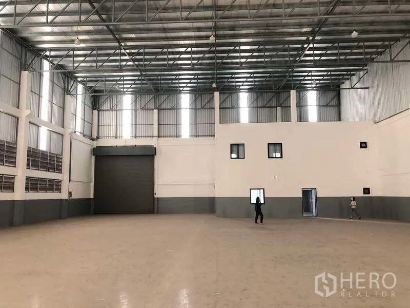Factory for rent or sale in Bang Phli, Samut Prakan - Open factory floor showing loading roller door and attached internal office block.