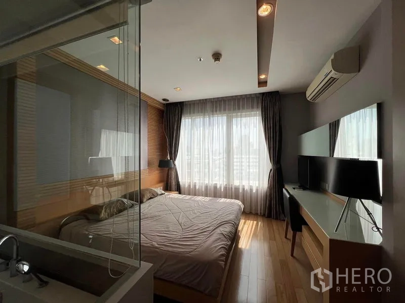 คอนโด ให้เช่าในKhlong Toei, Bangkok - ห้องนอนสว่าง มีหน้าต่างบานใหญ่ โต๊ะทำงาน และฉากกระจกกั้นห้องน้ำ