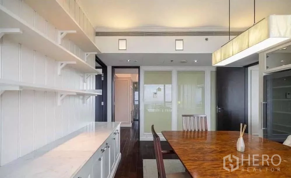Condominium for rent in Sathon, Bangkok - Pantry or study area with wall shelving, marble counter and wood table under a pendant light.