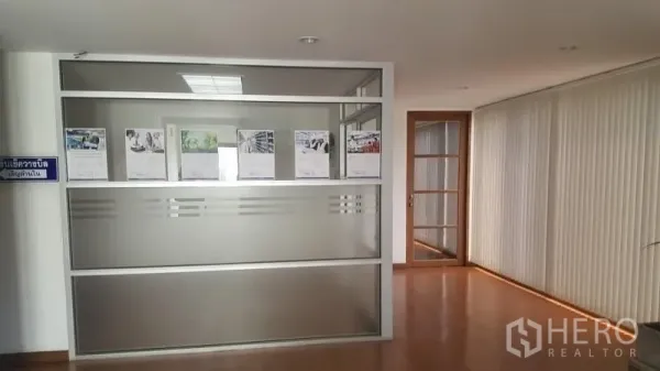 Warehouse for rent in Suan Luang, Bangkok - Office corridor with frosted glass partition and glass door leading to meeting rooms.