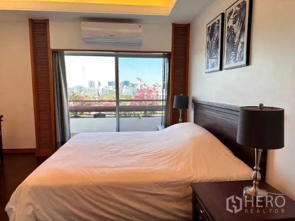 房间 出租 - 主卧带观景阳台，落地滑门与床头灯，可眺望城市与隆比尼公园一带。