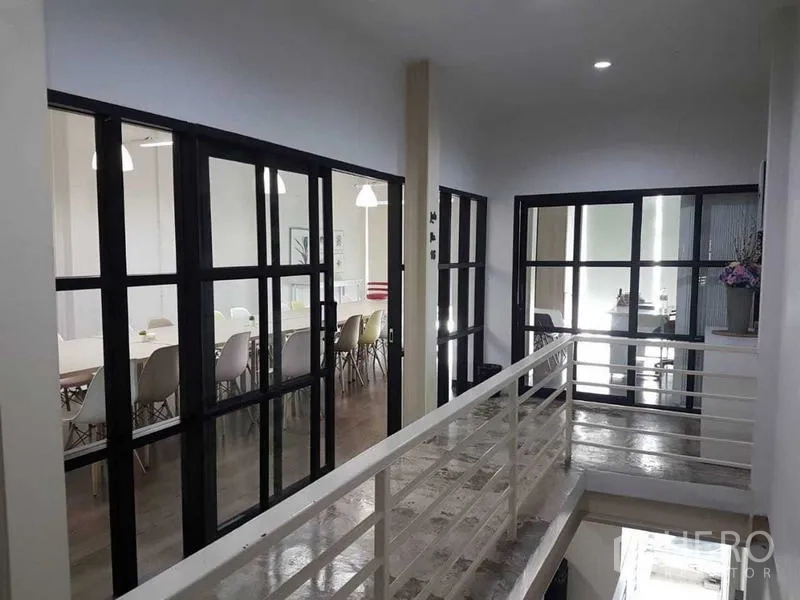 店屋 出售在Bang Rak, Bangkok - 上层会议室与办公间，黑框玻璃隔断，可见座椅与吊灯。