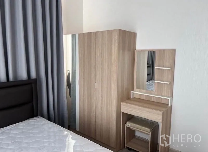 คอนโด ให้เช่าในBang Rak, Bangkok - มุมห้องนอนพร้อมตู้เสื้อผ้าและโต๊ะเครื่องแป้งไม้โทนอ่อน