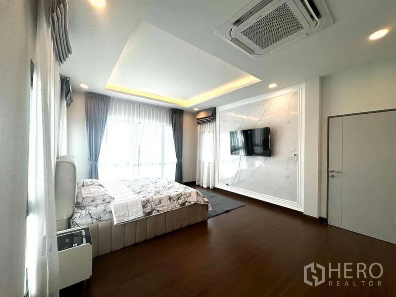 Detached House for rent in Bang Phli, Samut Prakan - Master bedroom view with wall‑mounted TV, large windows and recessed lighting