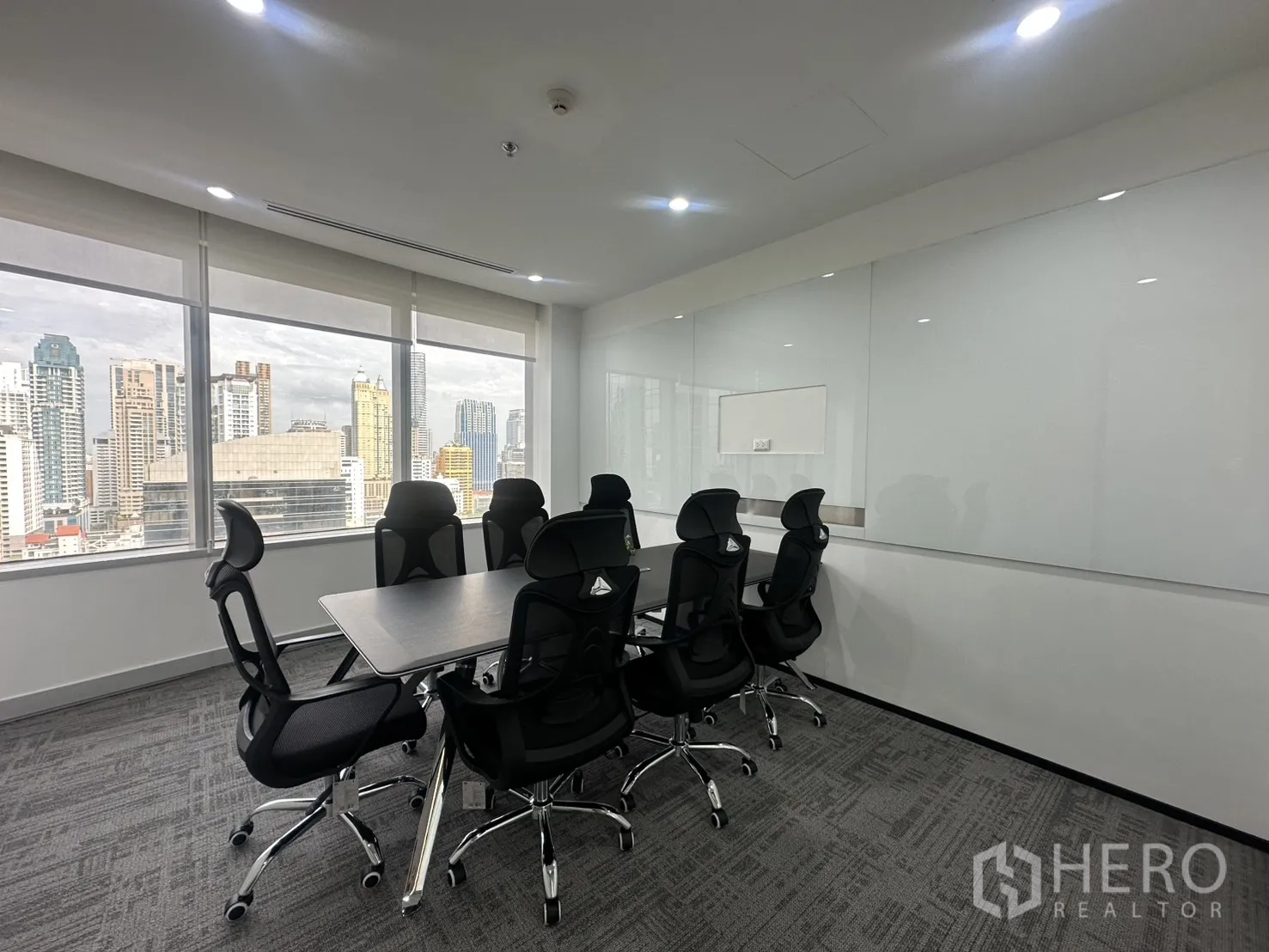 办公室 for rent in Pathum Wan, Bangkok - 会议室配桌椅与整面白板墙，临窗可观城市天际线。