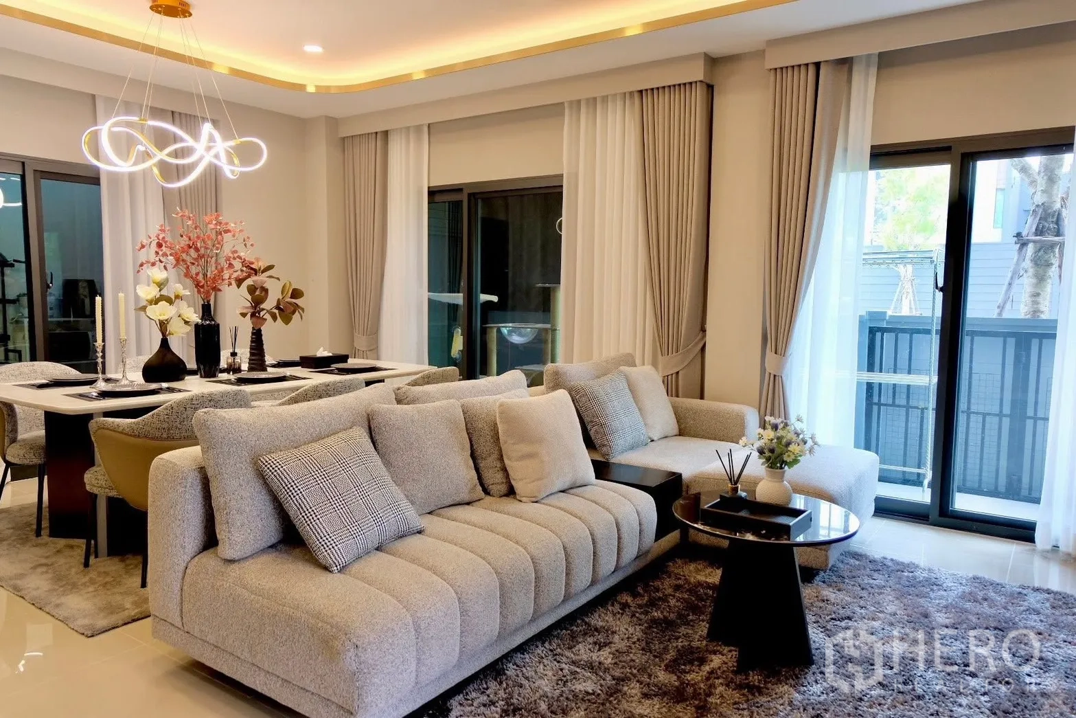 Semi-detached House for sale in Prawet, Bangkok - Cozy living room with large sofa, sliding glass doors and drapes.