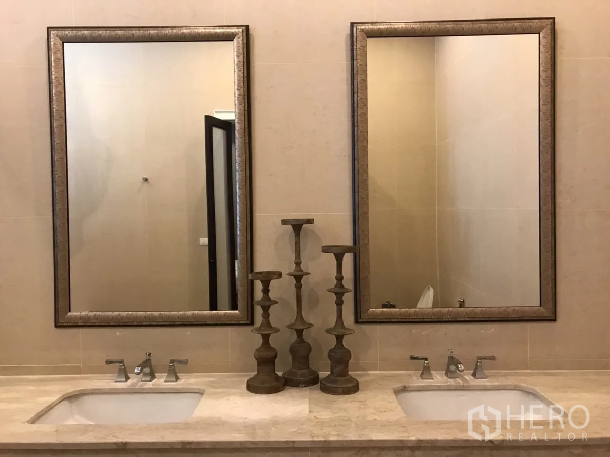 Condominium for rent or sale in Huai Khwang, Bangkok - Double vanity bathroom with twin framed mirrors, stone countertop and chrome taps in a modern condo.
