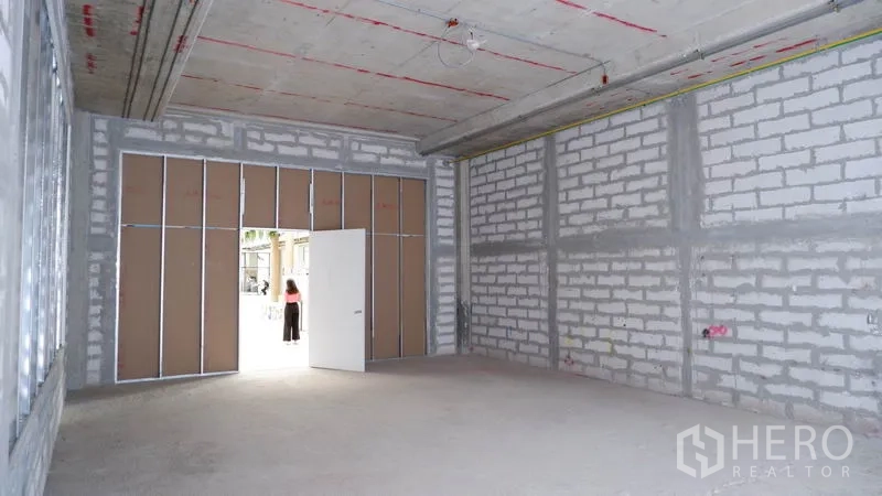 พื้นที่ขายปลีก ให้เช่าในKhlong Toei, Bangkok - ภายในพื้นที่ค้าปลีกโล่ง แสดงทางเข้ากว้างและผนังบล็อกพร้อมตกแต่ง.