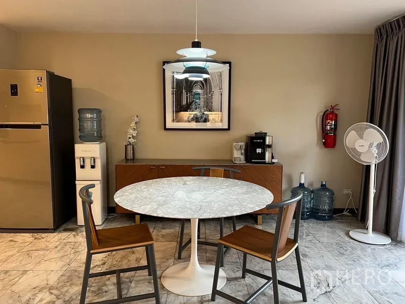 Townhouse for sale in Suan Luang, Bangkok - Dining nook with round marble table, pendant light, fridge and sideboard.