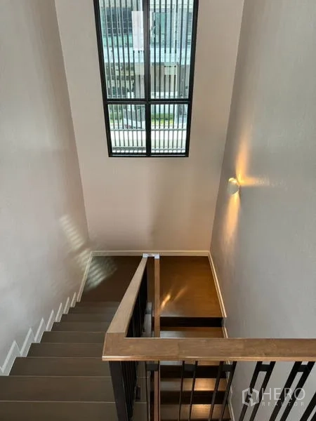 Detached House for rent or sale - Staircase with metal railing and tall window bringing in natural light.