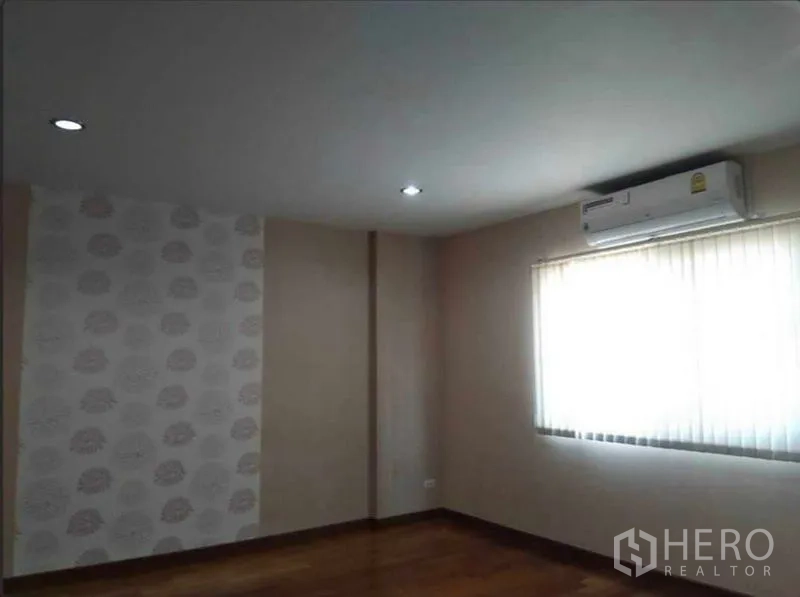 Home Office for rent in Bueng Kum, Bangkok - Air-conditioned bedroom with window blinds, accent wallpaper and wood flooring.