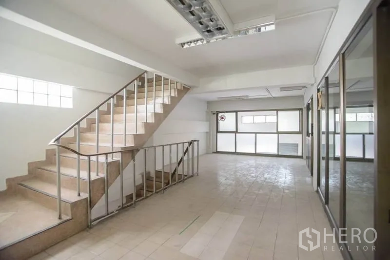 店屋 出租在Wang Thonglang, Bangkok - 室内楼梯间，瓷砖台阶、不锈钢扶手与磨砂窗。