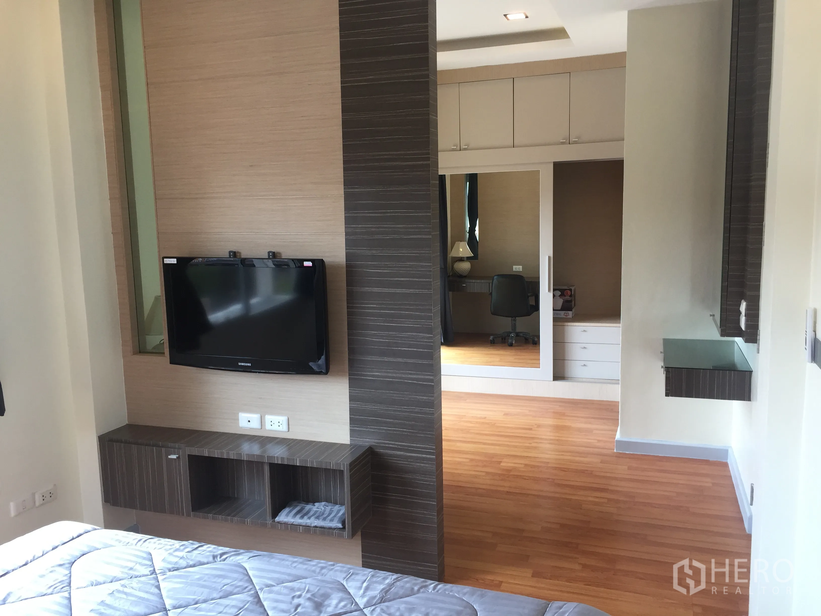 บ้าน ขายในLat Krabang, Bangkok - มุมห้องนอนใหญ่ มีทีวีติดผนัง ตู้เสื้อผ้าบานกระจก และมุมทำงาน