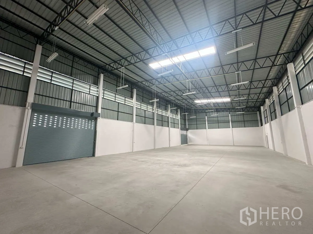 Factory for rent in Bang Len, Nakhon Pathom - Wide warehouse interior with polished concrete floor and large roller shutter.