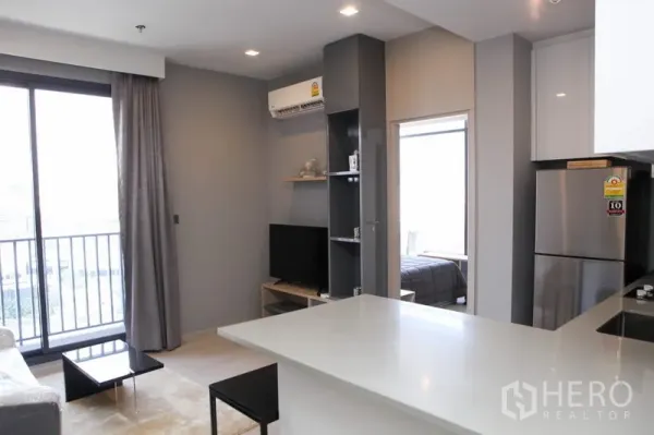 Condominium for rent in Watthana, Bangkok - Bright open-plan living room with balcony, TV unit and breakfast bar in a modern Bangkok condo.