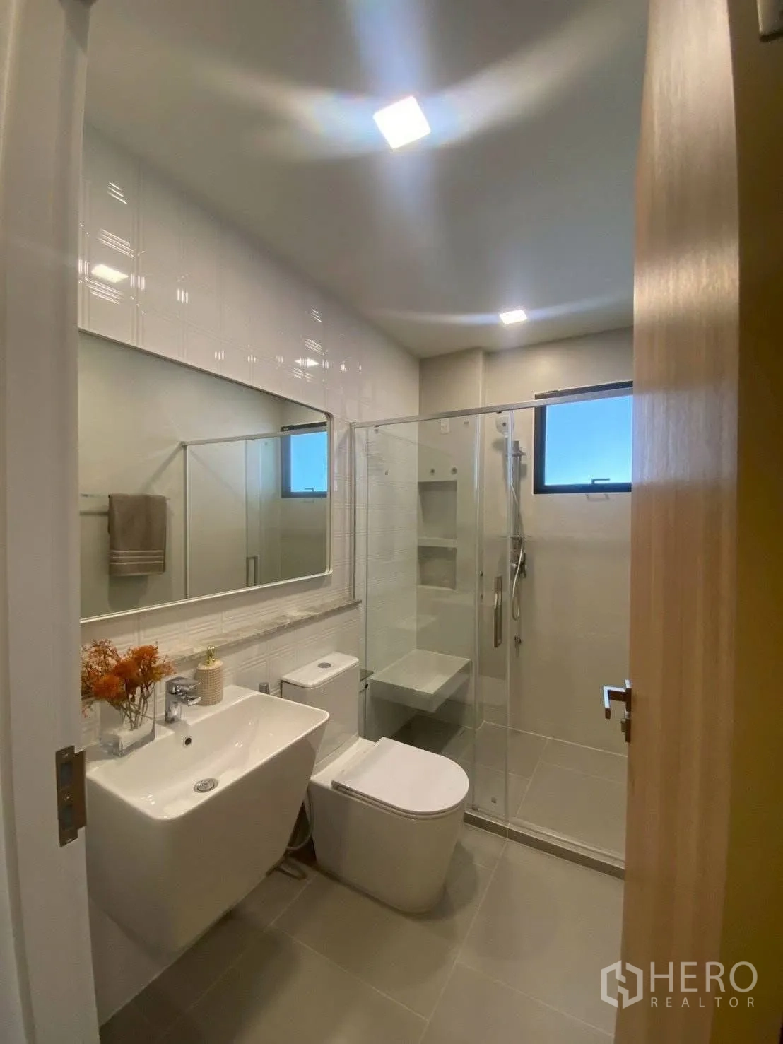 Detached House for rent in Bang Phli, Samut Prakan - Clean bathroom with large mirror, vanity, toilet and glass shower.