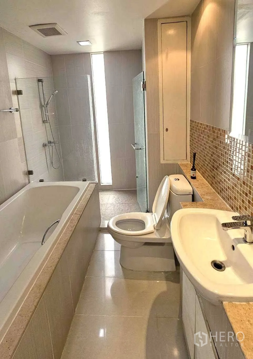 คอนโด ให้เช่าในWatthana, Bangkok - ห้องน้ำสมัยใหม่ อ่างอาบน้ำ ฝักบัวกระจก อ่างล้างหน้า และผนังกระเบื้องโมเสก