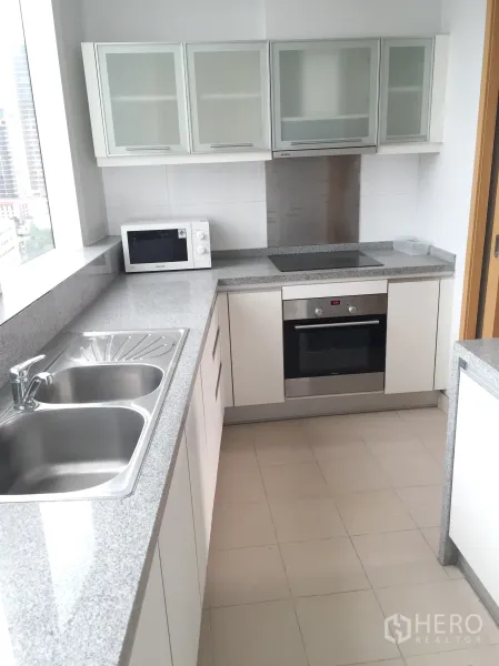 คอนโด ให้เช่าในKhlong Toei, Bangkok - ครัวปิดสว่างตา เคาน์เตอร์หินแกรนิต อ่างล้างจานคู่ เตาอบ และหน้าต่างวิวเมือง