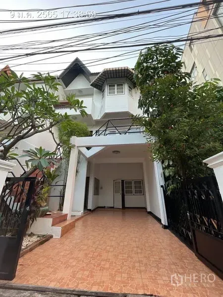 Detached House for rent in Khlong Toei, Bangkok - Multi-storey detached house exterior with gated driveway, tiled carport and mature trees.